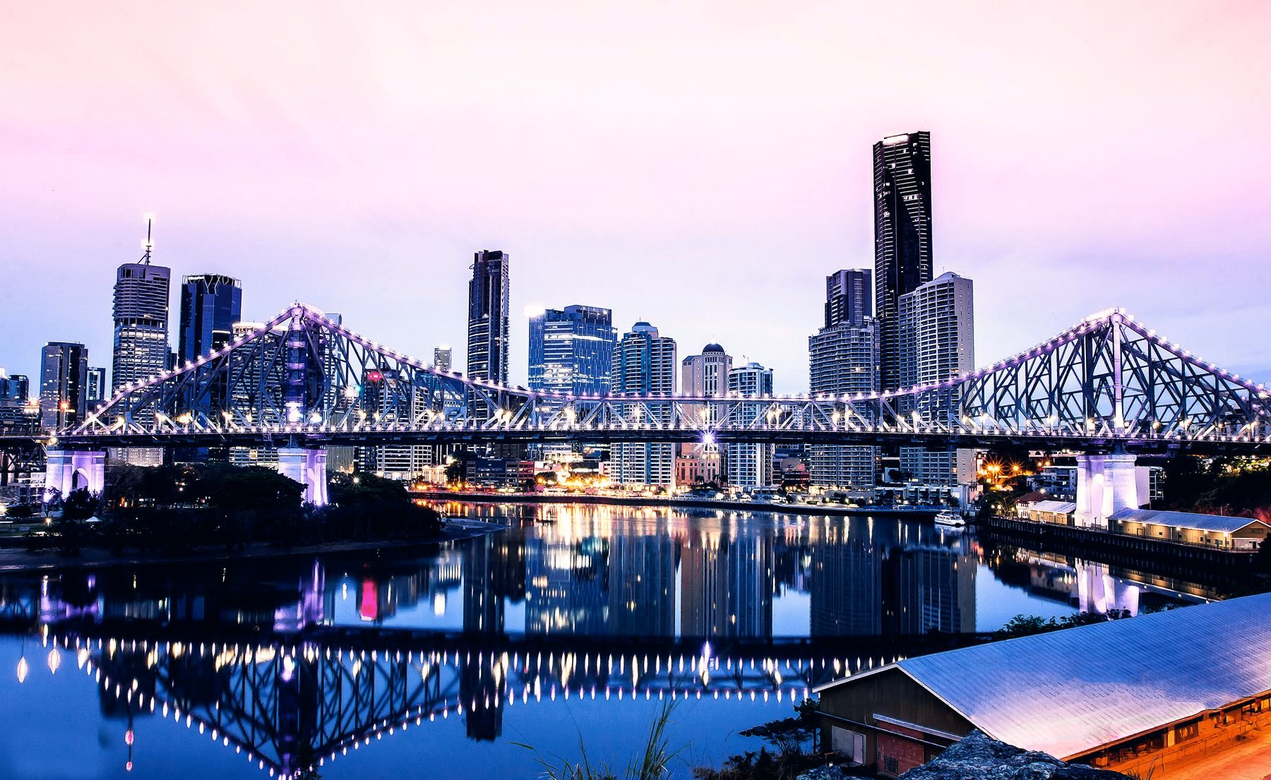 A city bridge lit up at dusk
